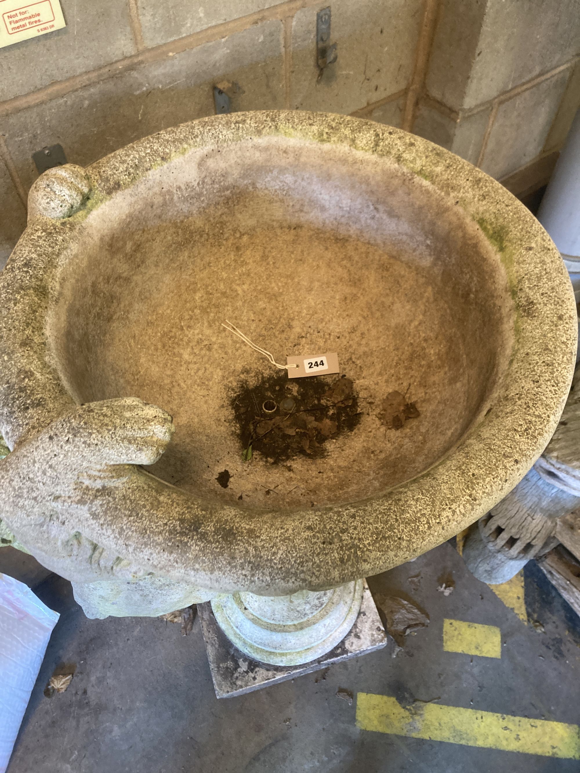 A reconstituted stone garden fountain modelled as a hound drinking from a circular bowl, width 80cm height 112cm